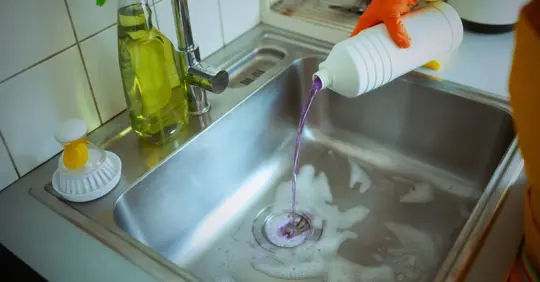 Pouring Drain Cleaner into Kitchen Sink